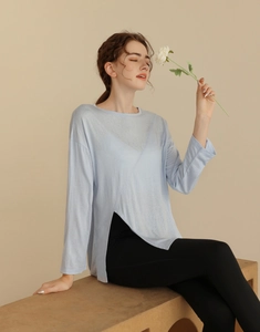 Détail du haut de yoga bleu clair avec fente latérale asymétrique et tissu respirant