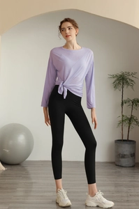 Détail du haut de yoga lilas avec nœud élégant et legging noir à taille haute moulant