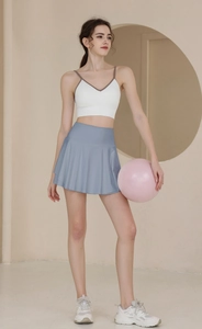 Dettaglio gonna da tennis a pieghe a vita alta con tasche e reggiseno sportivo bianco