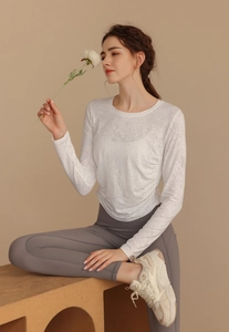 Detail von weißem Jacquard-Yoga-Top mit Raffung und grauen High-Waist-Leggings