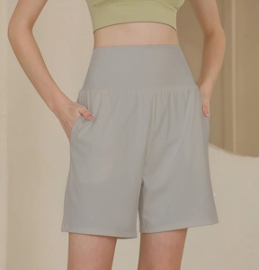 Detail einer grauen Yoga-Shorts mit hoher Taille, Seitentaschen und weitem Bein