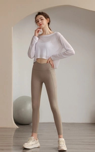 Detail von lockerem, weißem Mesh-Yoga-Oberteil mit High-Waist-Leggings und praktischer Tasche