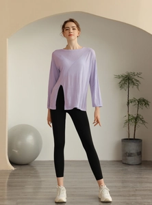 Détail du haut de yoga lilas en tencel avec fente latérale et legging de sport noir