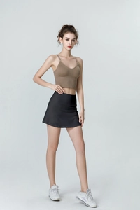Close-up of brown ribbed knit crop top and black high-waisted sports skort set