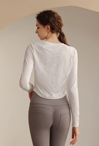Detailansicht der Jacquard-Stoffstruktur auf dem weißen Sportoberteil für Damen