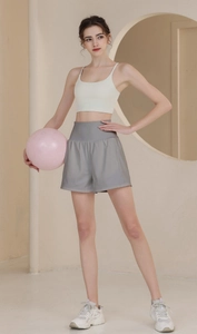 Women's cream sports bra and grey loose training shorts with a fitness ball yoga set
