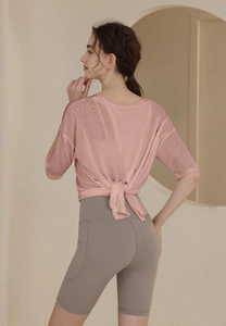 Detail of pink sports t-shirt with back knot design and gray cycling shorts with pockets