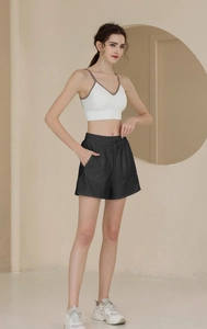 Detail of loose black nylon sports shorts featuring a drawstring waist and side pockets