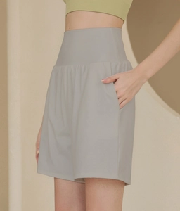 Detail der grauen Yoga-Shorts mit hohem Bund und Seitentasche für Damen beim Training