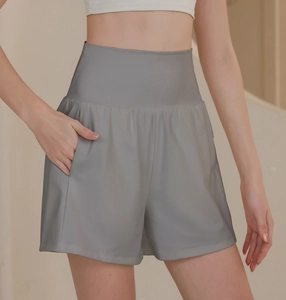 Detailed shot of high-waisted gray sports shorts featuring wide waistband and side pockets