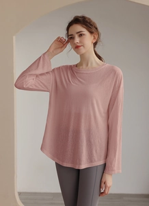 Macro detail of breathable pink loose yoga top with delicate textured fabric and crew neck