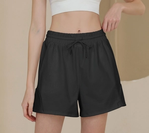 Close-up of black high-waisted nylon sports shorts with elastic drawstring and curved hem