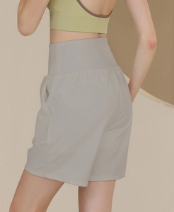 Detailansicht grauer Yoga-Shorts mit hoher Taille, Seitentasche und breitem Bunddesign