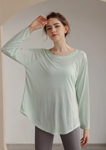 Close-up of mint green long sleeve yoga cover-up with breathable texture and loose hem