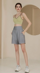 Detail der grauen, locker sitzenden Yoga-Shorts mit Seitentaschen und avocadogrünem Oberteil