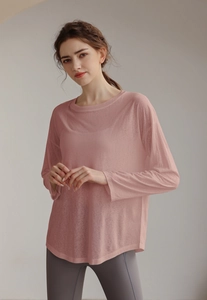 Detailed texture of pink sheer mesh sports top with long sleeves and loose-fit design