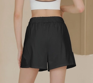 Detail of high-waist elastic waistband on loose black athletic shorts with dry-fit fabric