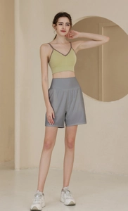 Detail eines grünen V-Ausschnitt Sport-BHs und grauen High-Waist Shorts Sets für Damen