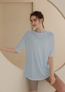 Detail view of women's light blue loose workout t-shirt with side slits and breathable fabric