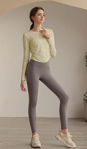 Detail eines schmal geschnittenen atmungsaktiven Yoga-Langarmshirts mit Taillenfalte