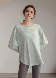 Macro shot of mint green tencel fabric texture on a loose-fit yoga long sleeve shirt