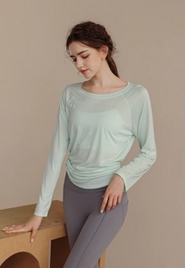 Close-up of light green tencel yoga top with breathable semi-transparent fabric texture