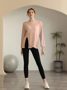 Détail d'un haut de yoga rose ample avec fente latérale haute et maille respirante
