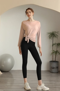 Détail du haut de yoga rose clair avec un design élégant de nœud latéral