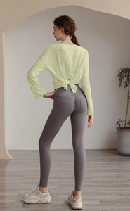 Detail of loose fit long sleeve yoga top with open back tie design and mesh texture