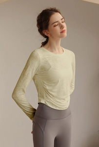 Detail des hellgrünen atmungsaktiven Jacquard-Stoffs und der Seitenfalten am Yoga-Oberteil