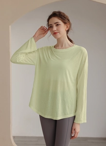 Close-up of lightweight pale lime green Tencel workout top with soft knit texture