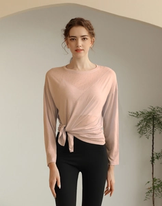 Détail d'un haut de yoga rose ample avec nœud latéral et texture tencel respirante