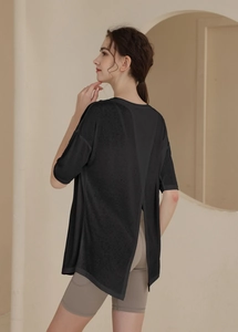 Detail view of the elegant cross-over split back design on a loose fit black sports top