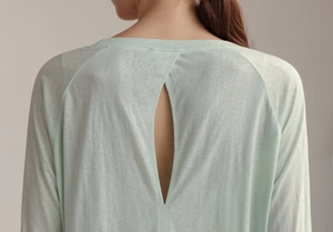 Detail of mint green yoga top featuring back cutout design and thin knit texture