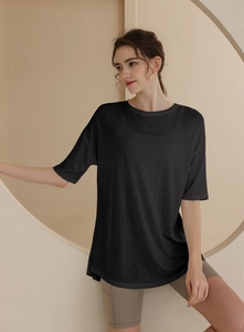 Detail of loose black sports T-shirt featuring breathable mesh fabric and curved hem