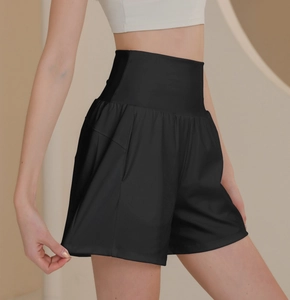 Detail showing high-waisted wide elastic waistband on black nylon sports shorts