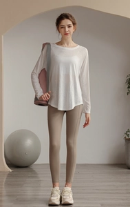 Detail view of white yoga mesh top and khaki leggings in a minimalist studio setting