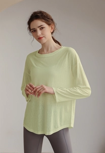 Detail view of light green breathable long-sleeve sports top with semi-sheer fabric
