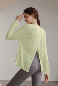 Detail view of the open-back slit design on a light yellow long-sleeve yoga top