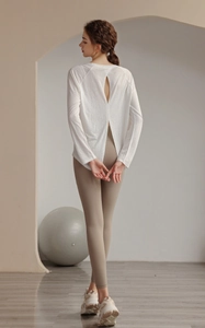 Detail of white yoga long sleeve top featuring an open back design and breathable fabric