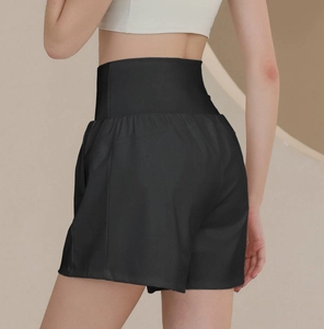 Detail view of high waisted black fitness shorts with tummy control on a model