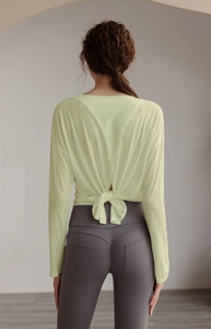 Detail view of Tencel sports top with unique back knot design and high waist yoga pants