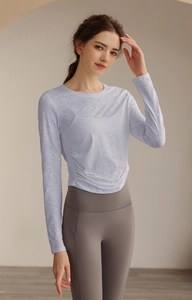 Detailaufnahme von atmungsaktivem Jacquard-Stoff und Knotensaum-Design am Yoga-Langarmshirt