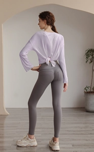 Detail showing the lavender yoga top with back knot design and grey high-waist gym leggings
