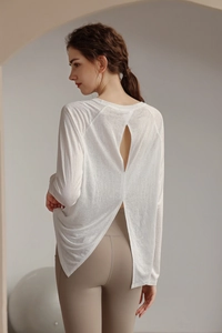 Detail of white yoga long sleeve top featuring elegant open back and split hem design