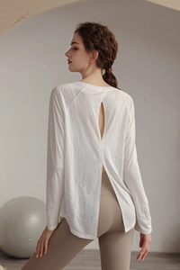 Detail of the back slit and deep V-neck cutout on this white yoga top for women