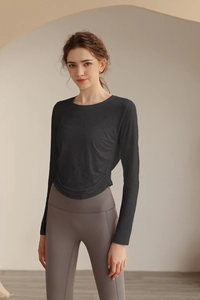 Detail des atmungsaktiven Jacquard-Stoffs und der Seitenfalten am schwarzen Yoga-Oberteil