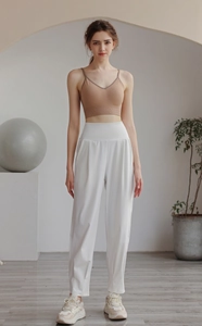 Detail of high-waist loose white joggers with khakhi sports bra for yoga and gym