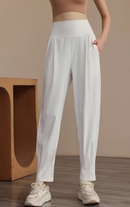 Detail of high-waist white sports trousers with wide waistband and side pockets