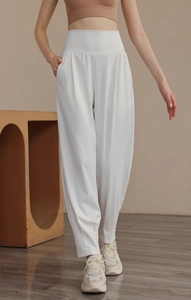 Close-up of high-waisted white yoga pants featuring functional side pockets and loose fit